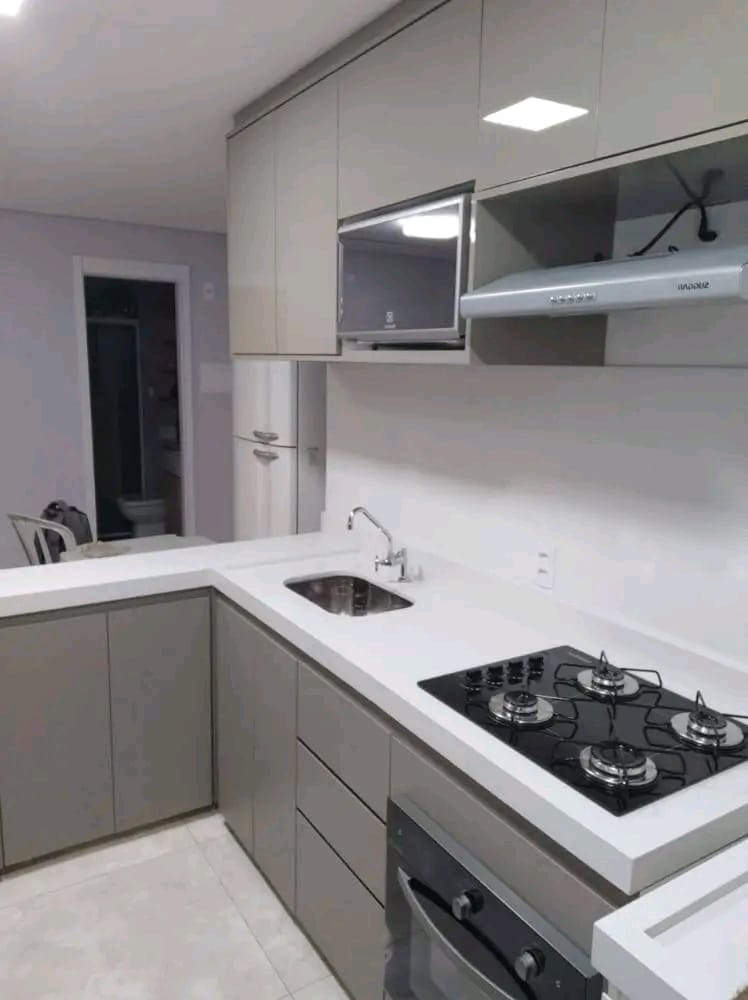Cozinha planejada com armários em acabamento cinza e coifa
